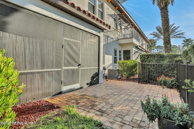 view of patio with central AC unit and fence