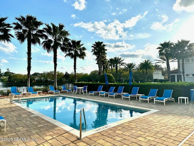 community pool with a patio and fence