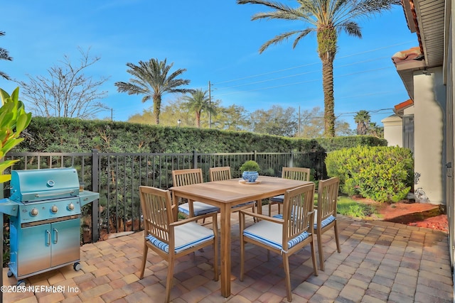 view of patio / terrace with a grill, outdoor dining space, and fence