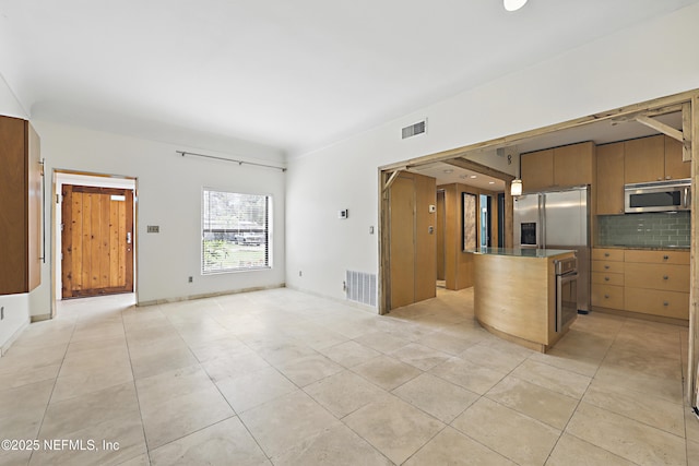 kitchen with visible vents, tasteful backsplash, appliances with stainless steel finishes, and open floor plan