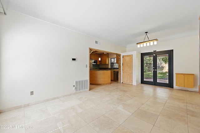 unfurnished living room with visible vents, baseboards, light tile patterned flooring, and french doors