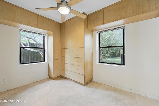 unfurnished room featuring baseboards and ceiling fan