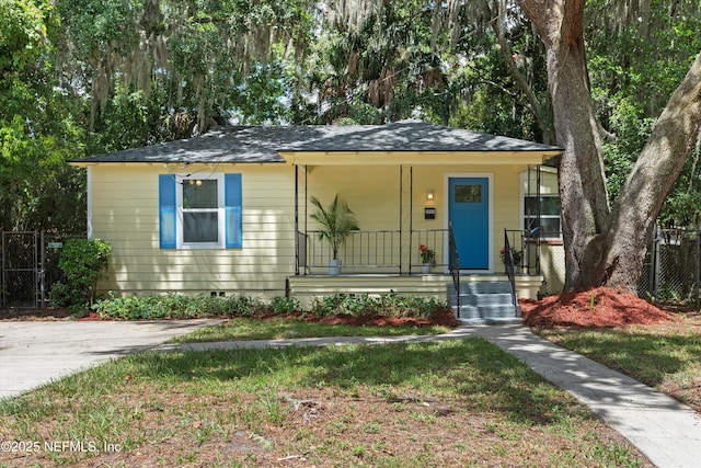 bungalow featuring fence, covered porch, and crawl space