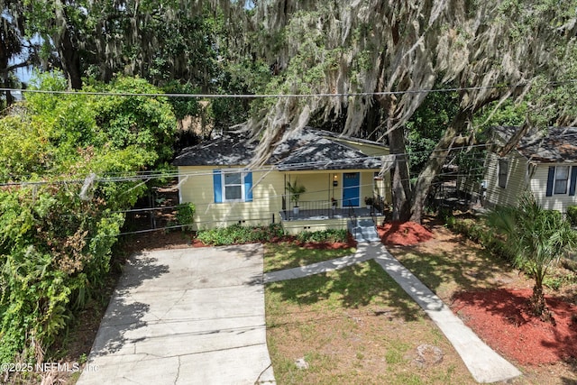 bungalow with a front yard, covered porch, and crawl space