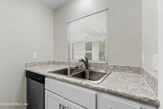 kitchen with a sink, stainless steel dishwasher, light countertops, and white cabinetry