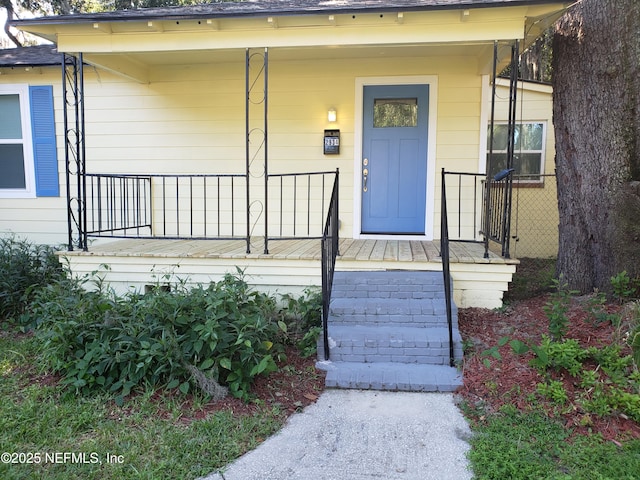 property entrance with a porch and a shingled roof