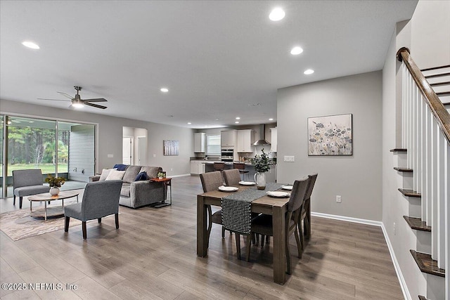 dining space with a ceiling fan, wood finished floors, recessed lighting, baseboards, and stairs