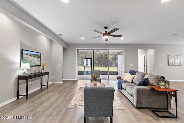 living room featuring light wood finished floors, visible vents, baseboards, ceiling fan, and recessed lighting