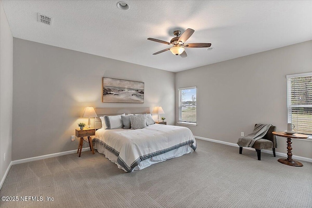 bedroom with visible vents, ceiling fan, baseboards, carpet, and a textured ceiling