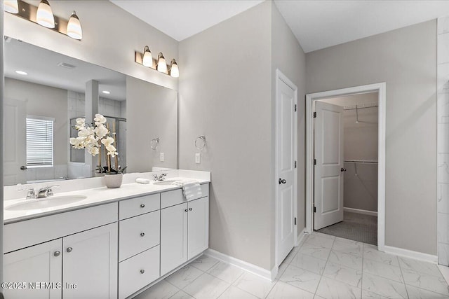 full bath featuring double vanity, baseboards, marble finish floor, and a sink