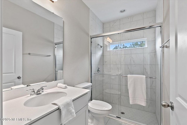 full bath with vanity, a shower stall, and toilet