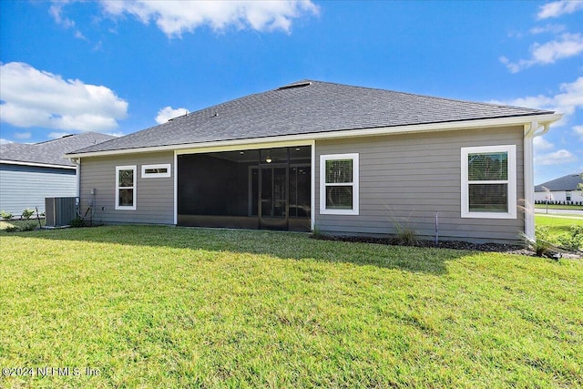 back of house with cooling unit, a lawn, a sunroom, and roof with shingles