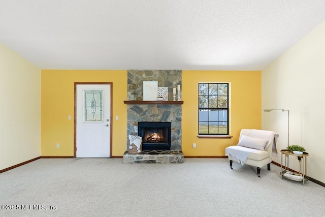 carpeted living area with baseboards, a textured ceiling, and a fireplace