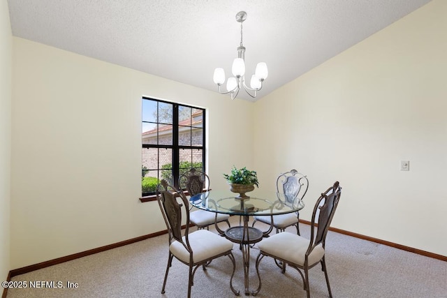 dining space with light carpet, a textured ceiling, baseboards, and an inviting chandelier