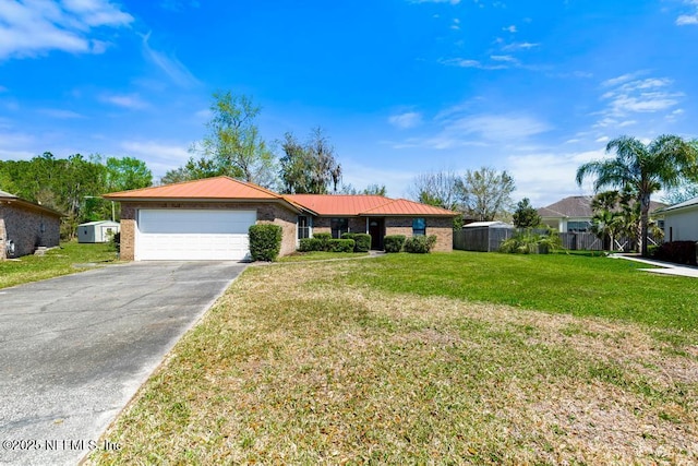 single story home with a garage, driveway, brick siding, and a front lawn