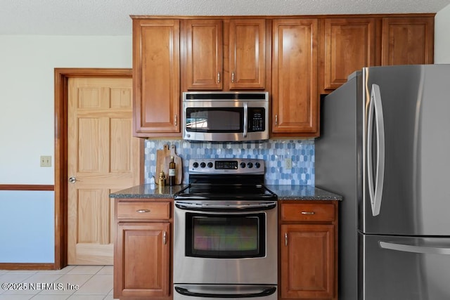 kitchen featuring decorative backsplash, brown cabinetry, and stainless steel appliances