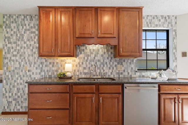 kitchen with brown cabinets, a sink, dark stone countertops, decorative backsplash, and dishwasher