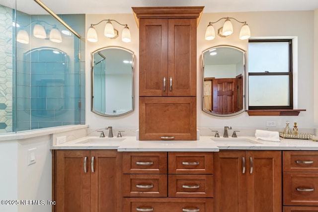 full bathroom with double vanity, tiled shower, and a sink