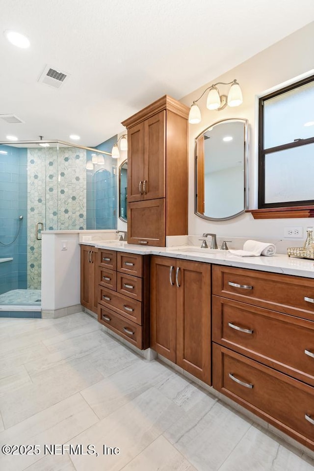 bathroom with visible vents, a shower stall, and vanity