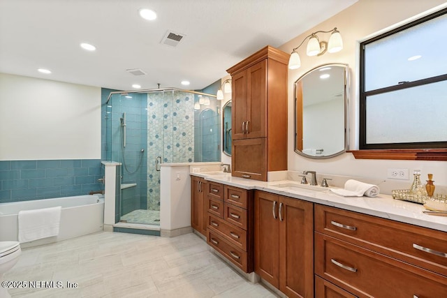 bathroom featuring double vanity, visible vents, a stall shower, and a sink