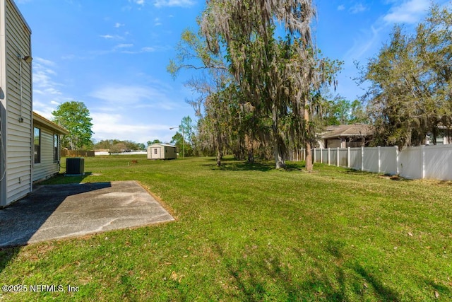 view of yard featuring an outdoor structure, a patio area, fence, and central AC