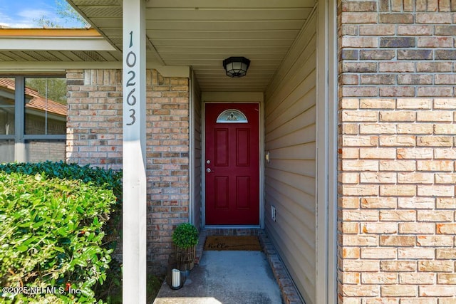 view of exterior entry with brick siding