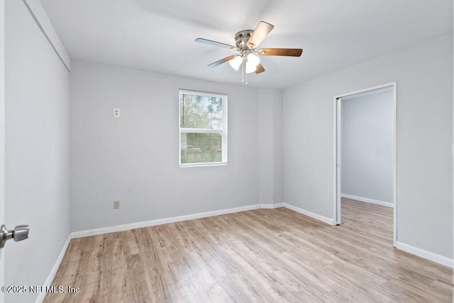 unfurnished room with a ceiling fan, light wood-type flooring, and baseboards