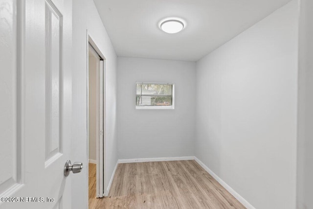 interior space with baseboards and light wood finished floors