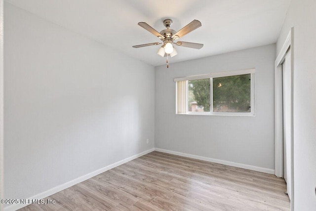 unfurnished bedroom featuring a closet, baseboards, a ceiling fan, and light wood finished floors