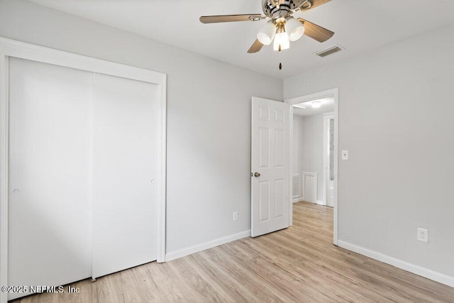 unfurnished bedroom with a closet, visible vents, light wood-style flooring, and baseboards