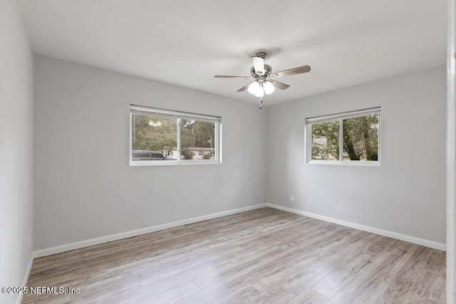 empty room with wood finished floors, baseboards, and ceiling fan