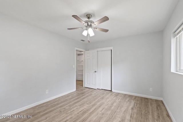 empty room featuring visible vents, wood finished floors, baseboards, and ceiling fan