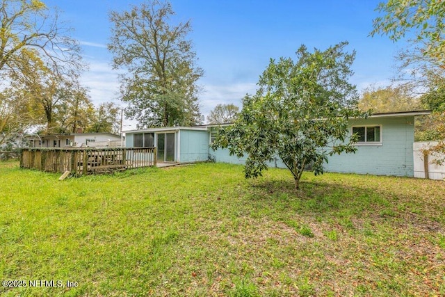 view of yard featuring a deck and a sunroom