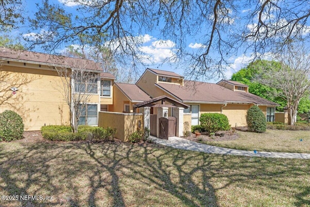 view of front of property with a front yard, fence, and stucco siding