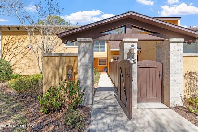 exterior space featuring a gate, a fenced front yard, and stucco siding