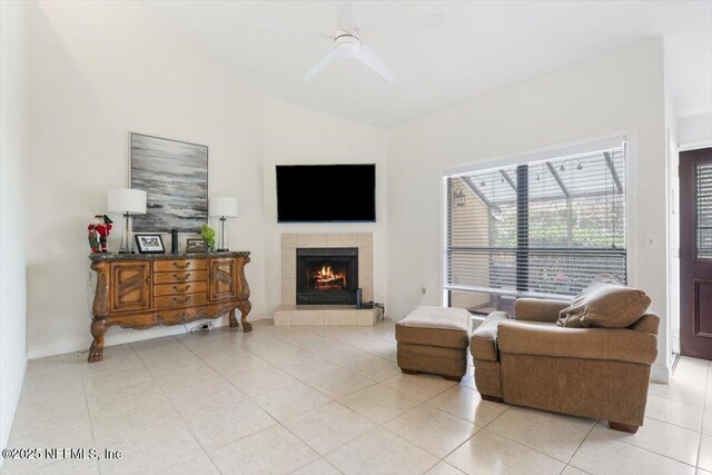 living room with a ceiling fan, lofted ceiling, light tile patterned flooring, and a fireplace