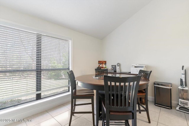 dining room featuring light tile patterned floors and lofted ceiling