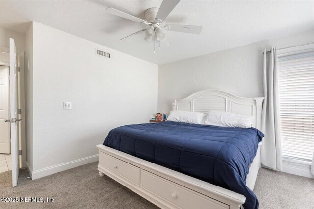 carpeted bedroom featuring a ceiling fan, baseboards, and visible vents