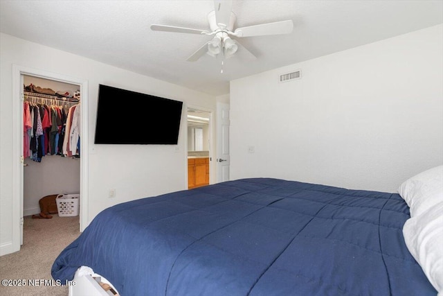 carpeted bedroom featuring a ceiling fan, visible vents, baseboards, a spacious closet, and a closet