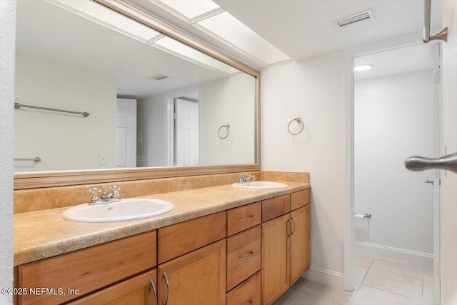 bathroom with tile patterned floors, visible vents, and a sink