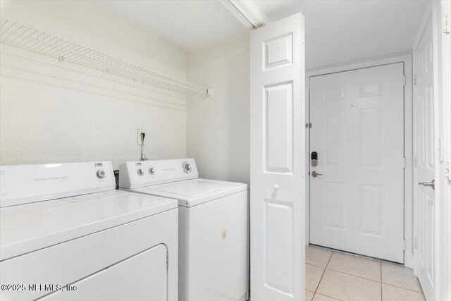 laundry room featuring laundry area, light tile patterned flooring, and washing machine and clothes dryer