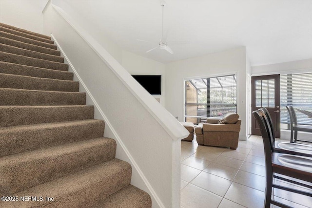 staircase featuring tile patterned floors and ceiling fan