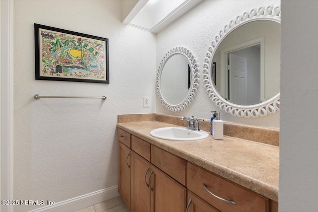 bathroom featuring baseboards, vanity, and tile patterned flooring