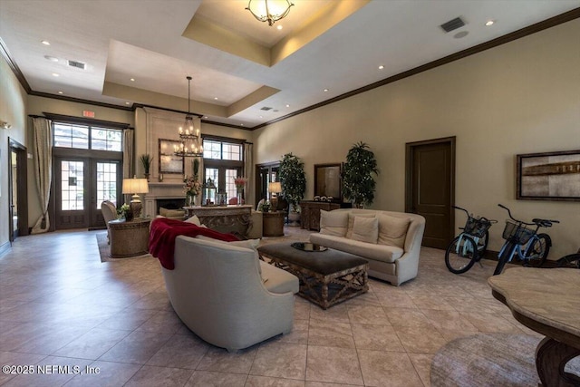 living room featuring visible vents, a raised ceiling, a healthy amount of sunlight, and a fireplace