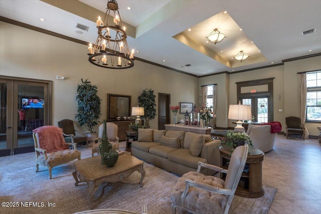 tiled living area featuring a tray ceiling, visible vents, ornamental molding, and french doors