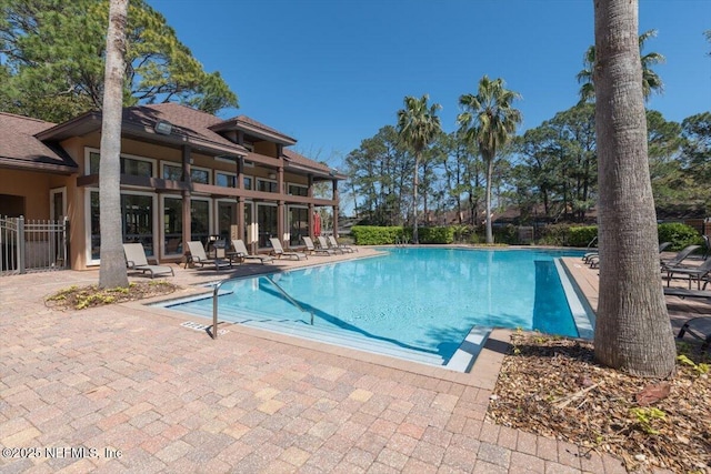 pool with a patio and fence