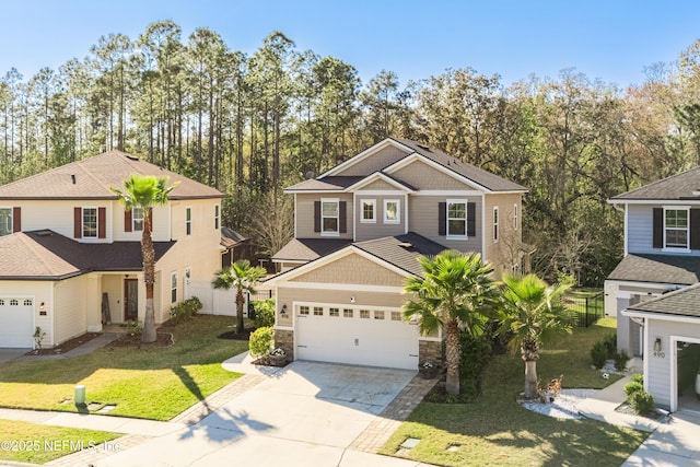 view of front of property with driveway, a front lawn, stone siding, fence, and a garage