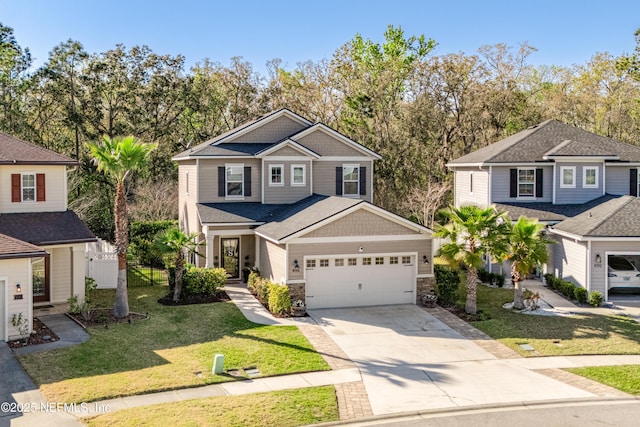 view of front of house featuring fence, a front yard, a garage, stone siding, and driveway