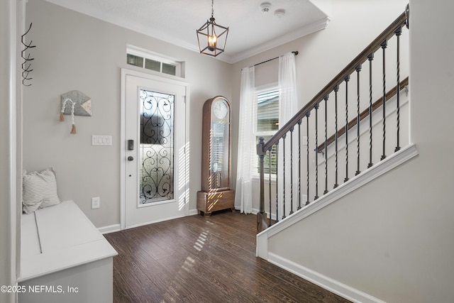 foyer entrance with dark wood-style floors, stairway, crown molding, and baseboards