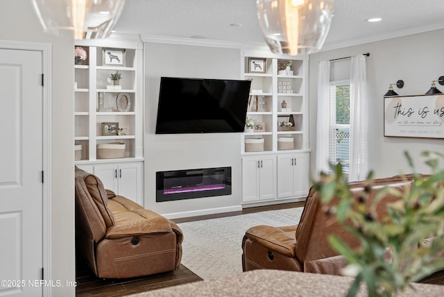 living area featuring a glass covered fireplace, wood finished floors, a textured ceiling, and ornamental molding